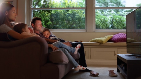 Family watching TV in living room